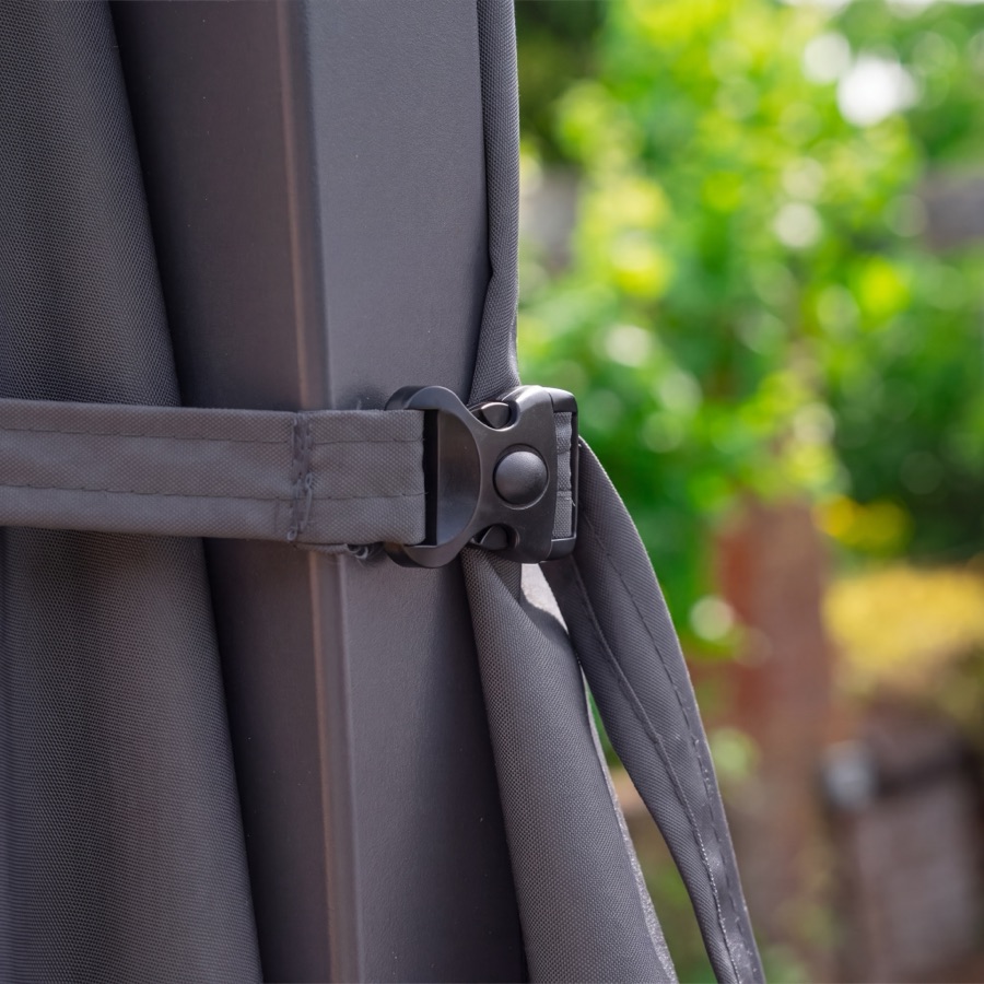 The retaining strap and buckle holding the folded canopy of a Nova cantilever parasol closed